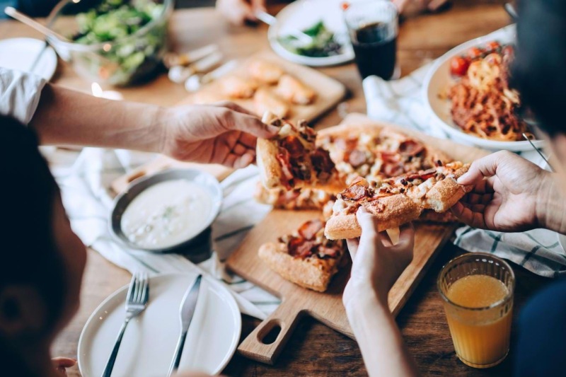 a group of people eating pizza